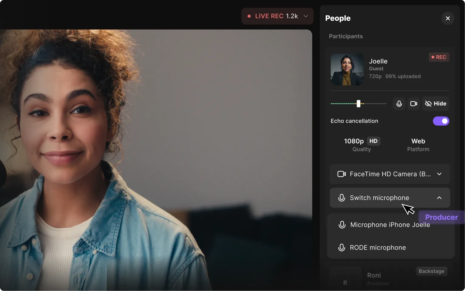 Young woman with curly hair smiling during a live video call with microphone and camera controls visible on screen.